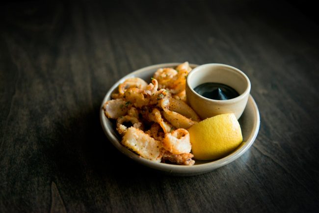 Breaded fried calamari and lemon wedge