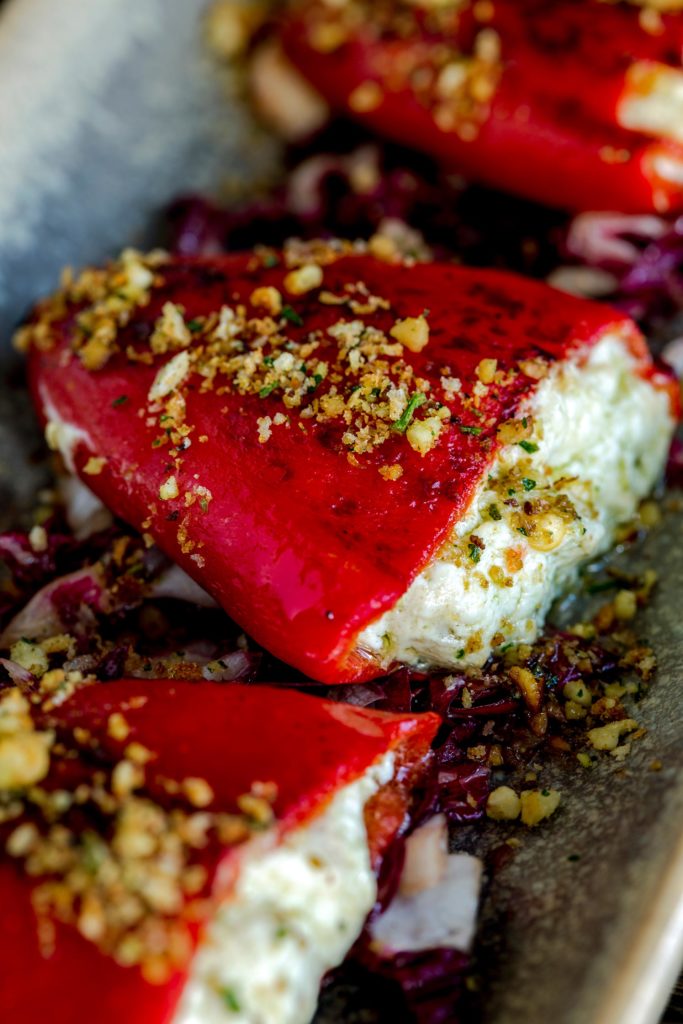 Cheese-filled red peppers topped with chopped garnish.