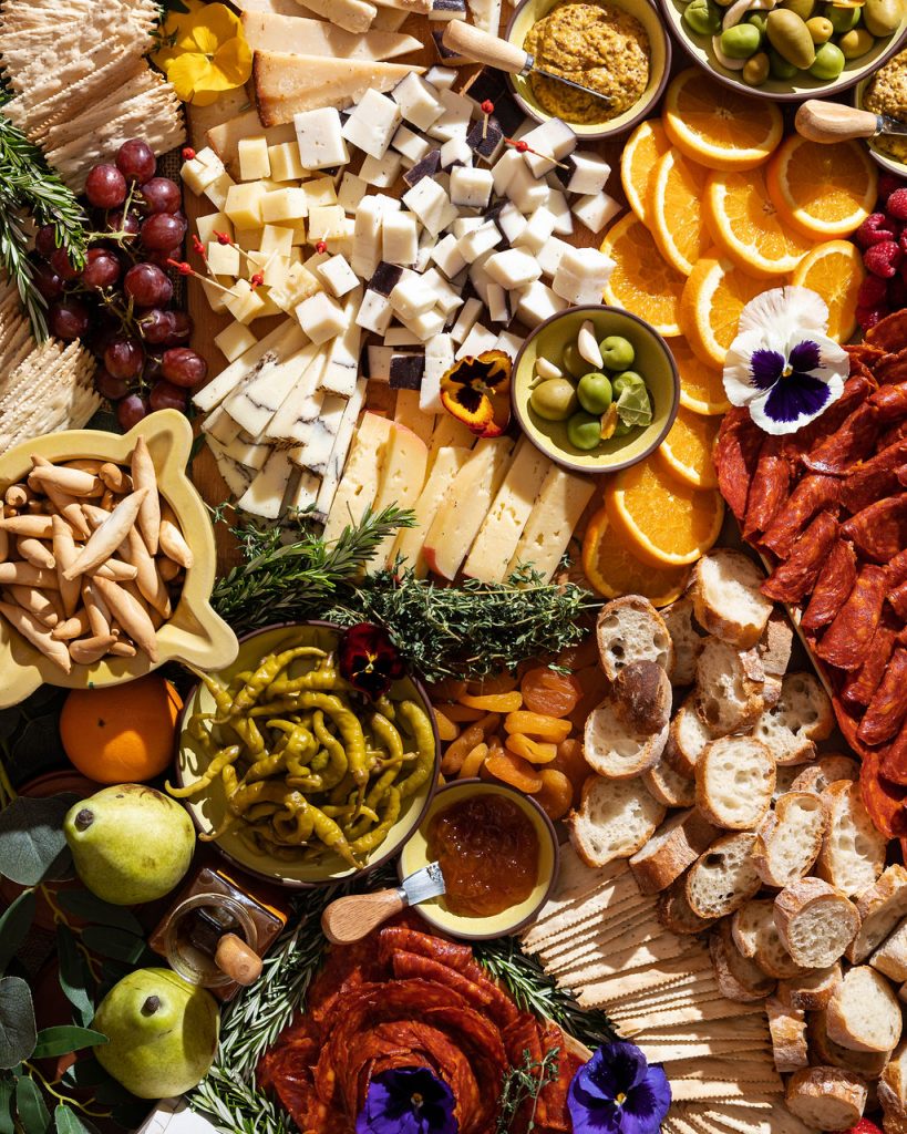 Spanish cheeses, cured meats, olives, fruit and crostini arranged for sharing.